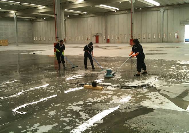 Equipe higienizando piso de galpão industrial de grande metragem